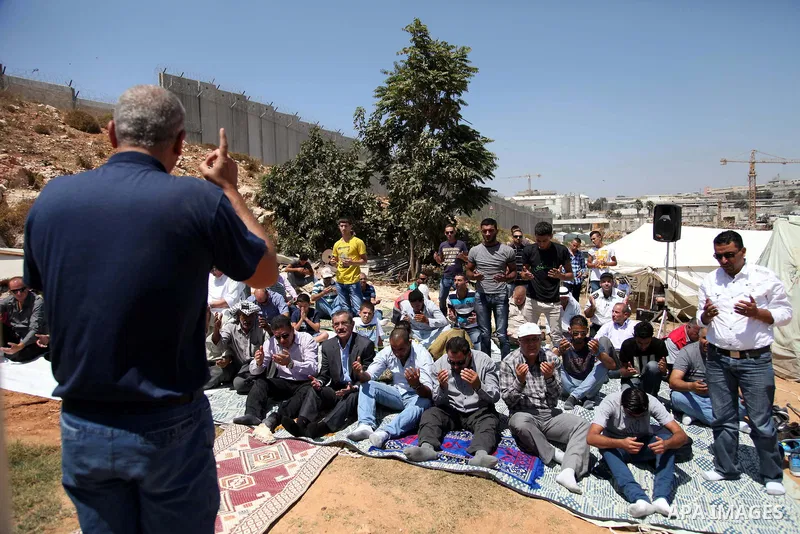 Palestinian from Ka'abneh Arabs attend Friday prayers in protest against evacuating them by Israeli bulldozers, in Bir Nabala near Jerusalem, Aug 23, 2013. Israeli authorities evacuated 53 Bedouin from residents of the c...