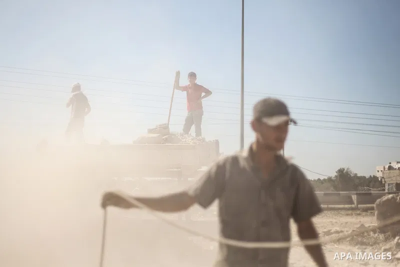 Palestinian laborers work on a crusher machine at a brick factory in center Gaza Strip, Aug 22, 2013. Palestinians re-use old bricks in construction after the Egyptian army started to knock down Gaza smuggling tunnels la...