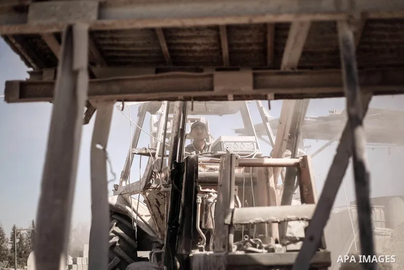 A Palestinian laborer works on a crusher machine at a brick factory in center Gaza Strip, Aug 22, 2013. Palestinians re-use old bricks in construction after the Egyptian army started to knock down Gaza smuggling tunnels...