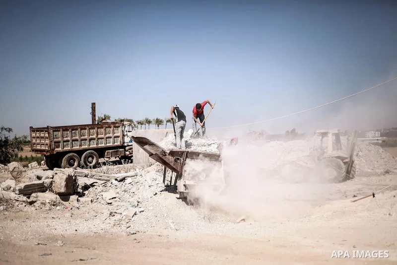 Palestinian laborers work on a crusher machine at a brick factory in center Gaza Strip, Aug 22, 2013. Palestinians re-use old bricks in construction after the Egyptian army started to knock down Gaza smuggling tunnels la...