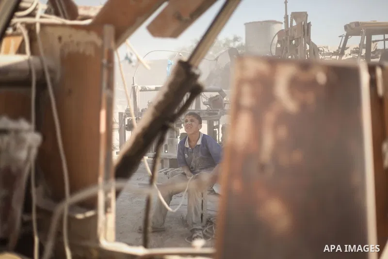 A Palestinian laborer works on a crusher machine at a brick factory in center Gaza Strip, Aug 22, 2013. Palestinians re-use old bricks in construction after the Egyptian army started to knock down Gaza smuggling tunnels...