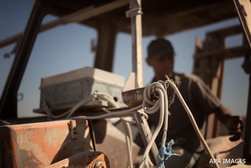 A Palestinian laborer works on a crusher machine at a brick factory in center Gaza Strip, Aug 22, 2013. Palestinians re-use old bricks in construction after the Egyptian army started to knock down Gaza smuggling tunnels...