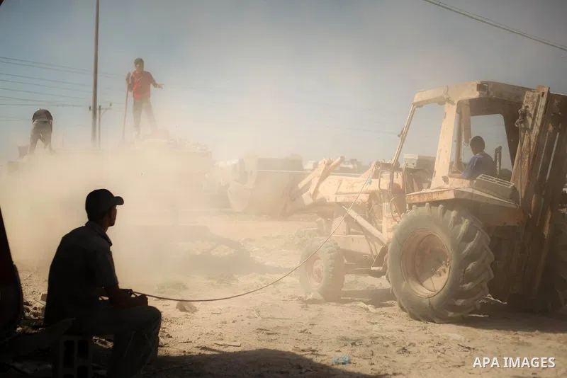 Palestinian laborers work on a crusher machine at a brick factory in center Gaza Strip, Aug 22, 2013. Palestinians re-use old bricks in construction after the Egyptian army started to knock down Gaza smuggling tunnels la...