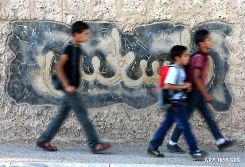Palestinian students return back to their school in the morning of the first day of the new year study in the West Bank city of Nablus, on Aug. 25, 2013. Photo by Nedal Eshtayah