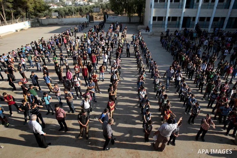 Palestinian students return back to their school in the morning of the first day of the new year study in the West Bank city of Nablus, on Aug. 25, 2013. Photo by Nedal Eshtayah