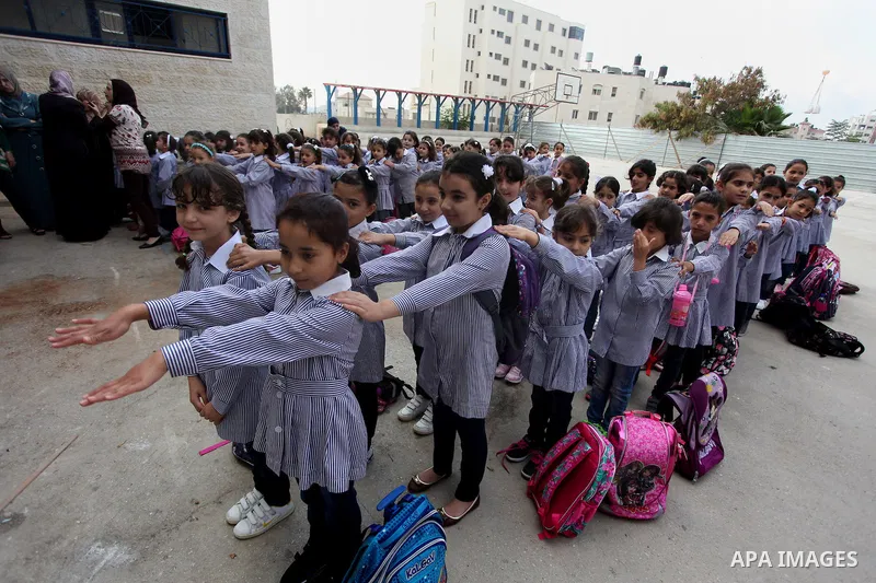 Palestinian students return back to their school in the morning of the first day of the new year study in the West Bank city of Ramallah, on Aug. 25, 2013. Photo by Issam Rimawi