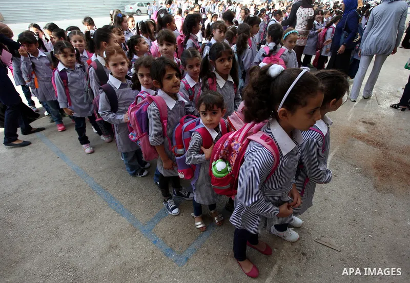 Palestinian students return back to their school in the morning of the first day of the new year study in the West Bank city of Ramallah, on Aug. 25, 2013. Photo by Issam Rimawi