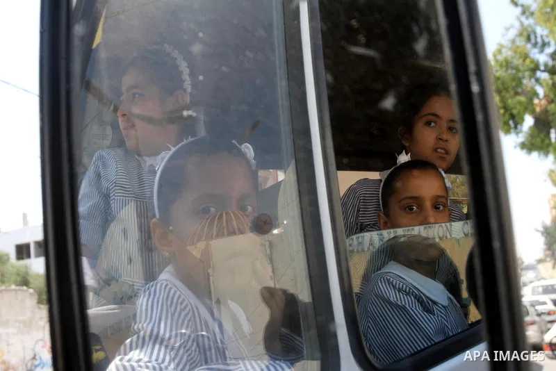 Palestinian students return back to their school in the morning of the first day of the new year study in Gaza city, on Aug. 25, 2013. Photo by Mohammed Asad