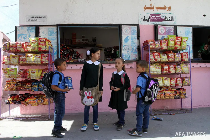Palestinian students return back to their school in the morning of the first day of the new year study in Gaza city, on Aug. 25, 2013. Photo by Mohammed Asad