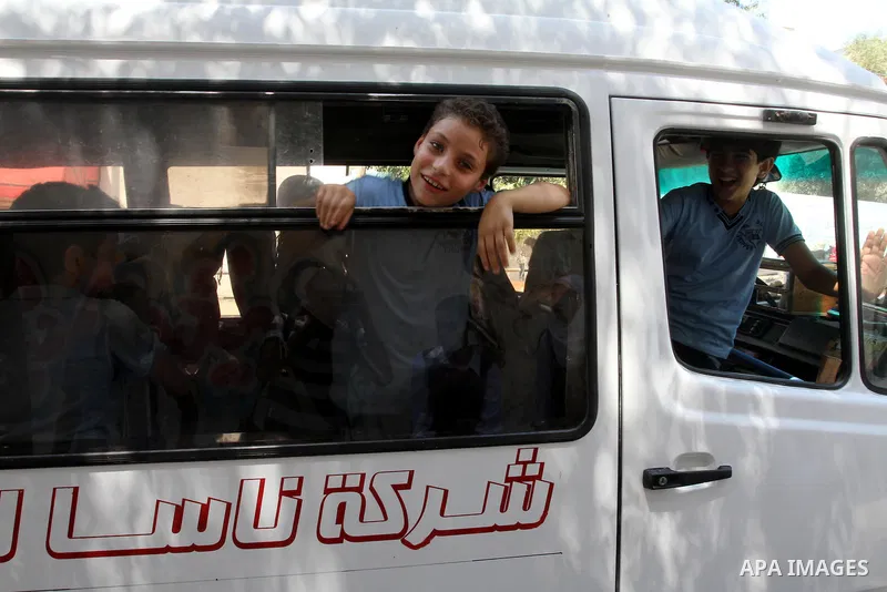 Palestinian students return back to their school in the morning of the first day of the new year study in Gaza city, on Aug. 25, 2013. Photo by Mohammed Asad