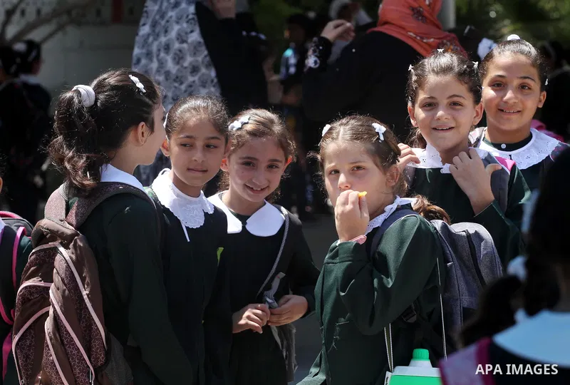 Palestinian students return back to their school in the morning of the first day of the new year study in Gaza city, on Aug. 25, 2013. Photo by Mohammed Asad