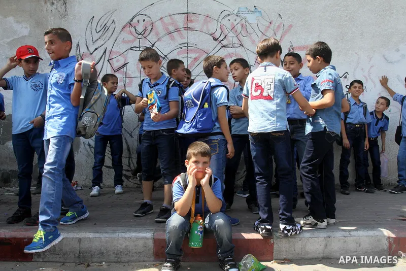 Palestinian students return back to their school in the morning of the first day of the new year study in Gaza city, on Aug. 25, 2013. Photo by Mohammed Asad