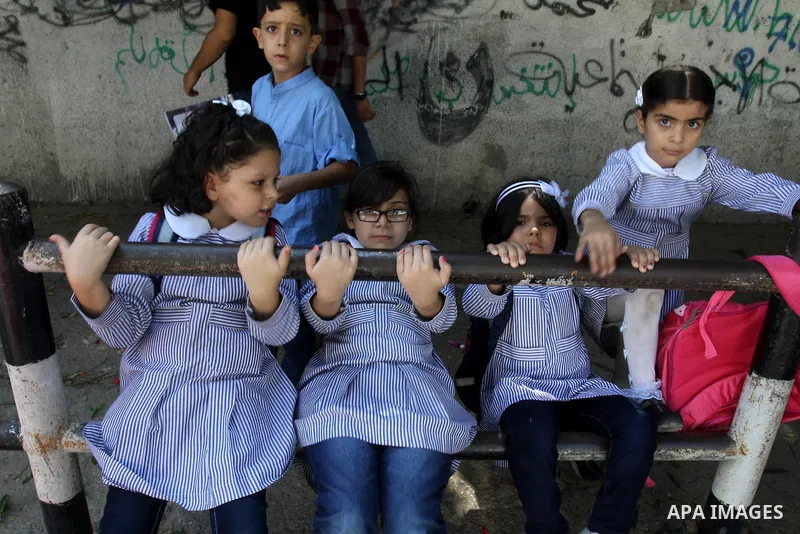 Palestinian students return back to their school in the morning of the first day of the new year study in Gaza city, on Aug. 25, 2013. Photo by Mohammed Asad