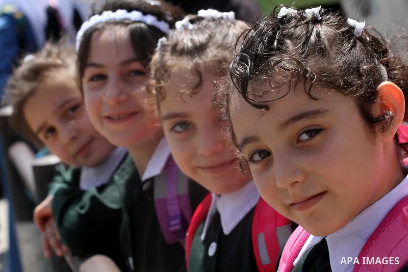 Palestinian students return back to their school in the morning of the first day of the new year study in Gaza city, on Aug. 25, 2013. Photo by Mohammed Asad