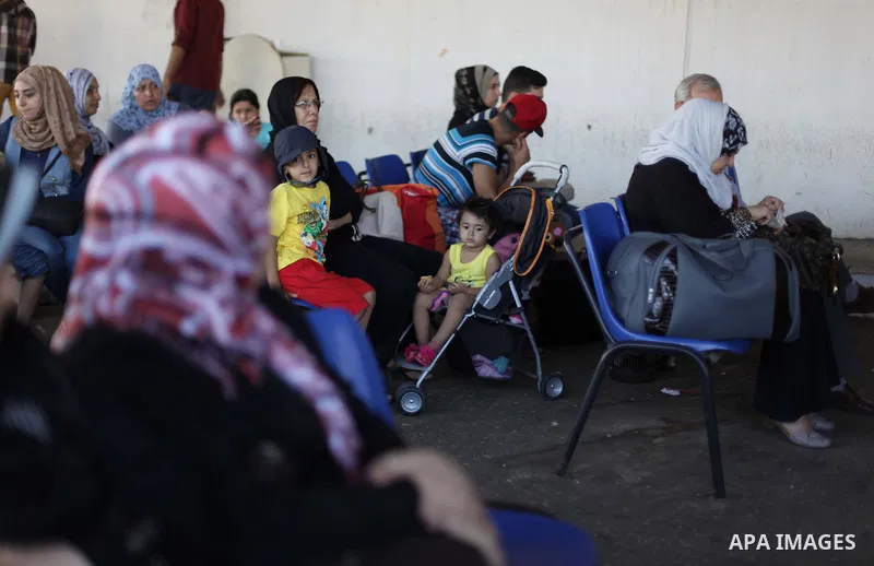 Palestinians wait to cross into Egypt at the Rafah crossing between Egypt and the southern Gaza Strip August 25, 2013. Egypt reopened its border crossing with the Gaza Strip on Saturday after four days of closure, allowi...