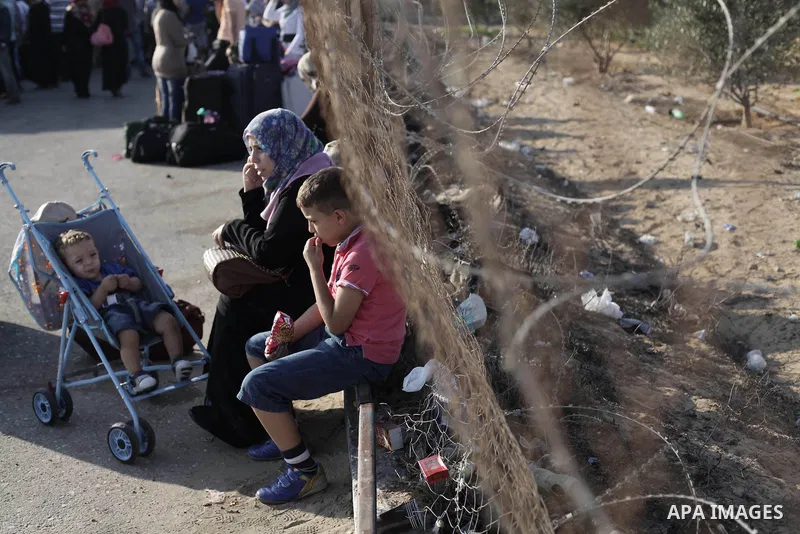 Palestinians wait to cross into Egypt at the Rafah crossing between Egypt and the southern Gaza Strip August 25, 2013. Egypt reopened its border crossing with the Gaza Strip on Saturday after four days of closure, allowi...