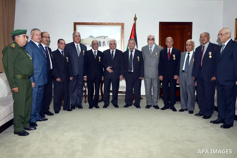 Palestinian President Mahmoud Abbas poses for a photograph with the former security chiefs following honoring ceremony in the West Bank City of Ramallah, Aug 25, 2013. Photo by Thaer Ganaim
