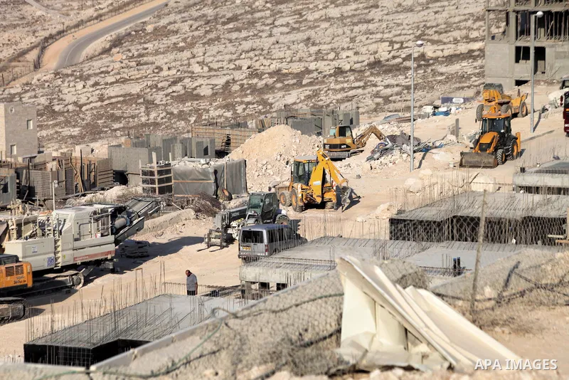 Laborers work at the construction site in Pisgat Zeev, an urban settlement in an area Israel annexed to Jerusalem after capturing it in the 1967 Middle East war, near the Arab village of Beit Hanina, August 25, 2013. Pal...