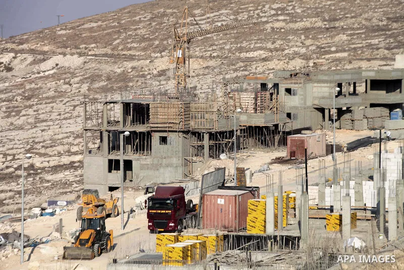 Laborers work at the construction site in Pisgat Zeev, an urban settlement in an area Israel annexed to Jerusalem after capturing it in the 1967 Middle East war, near the Arab village of Beit Hanina, August 25, 2013. Pal...