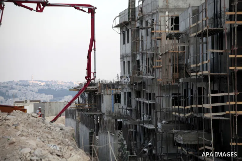 Laborers work at a construction site in Ramot, an urban settlement in an area Israel annexed to Jerusalem after capturing it in the 1967 Middle East war, August 25, 2013. Palestinian President Mahmoud Abbas last week rei...