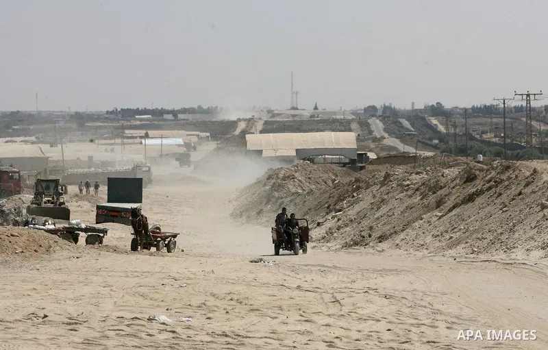Palestinians ride their tricycle next to the smuggling tunnels dug beneath the Gaza-Egypt border in the southern Gaza Strip on August 27, 2013. Egyptian security forces have stepped up a crackdown campaign on smuggling t...