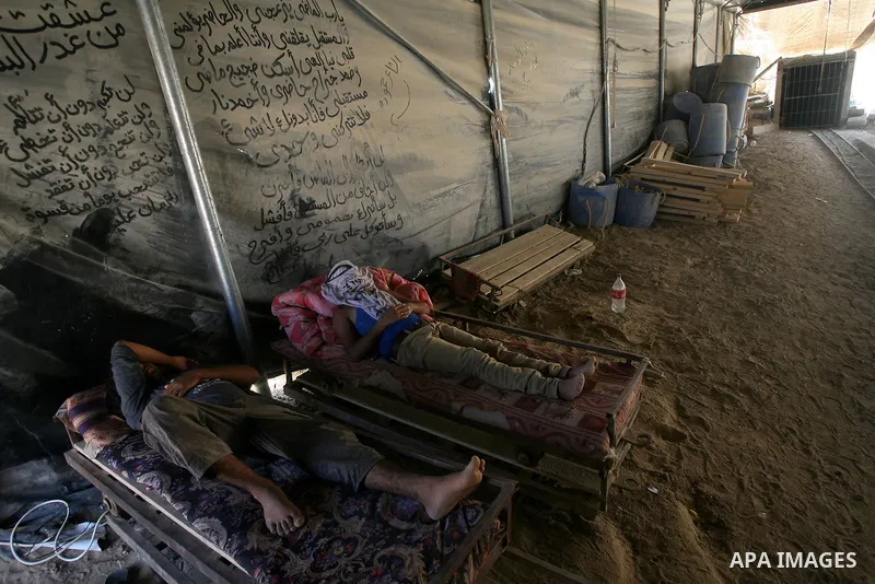 Palestinian tunnel workers rest at the entrance of a smuggling tunnel dug beneath the Gaza-Egypt border in the southern Gaza Strip on August 27, 2013. Egyptian security forces have stepped up a crackdown campaign on smug...