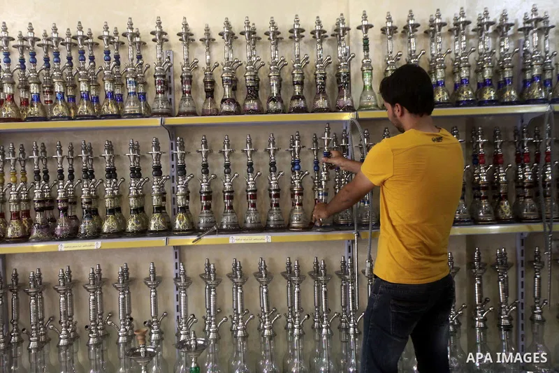A Palestinian man displays hookahs 'also known as waterpipes', at his shop in Gaza City on Aug 27, 2013. Photo by Ashraf Amra