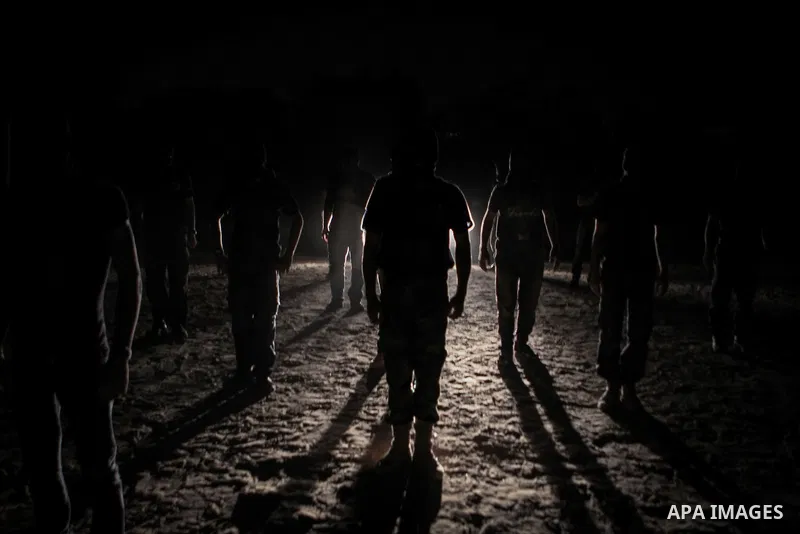 Palestinian militants of al-Nasser Salah al-Din Brigades, the armed wing of the Popular Resistance Committees (PRC), take part in a night military-style exercises at a training camp in Rafah in the southern Gaza Strip, A...