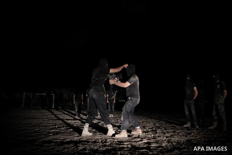 Palestinian militants of al-Nasser Salah al-Din Brigades, the armed wing of the Popular Resistance Committees (PRC), take part in a night military-style exercises at a training camp in Rafah in the southern Gaza Strip, A...