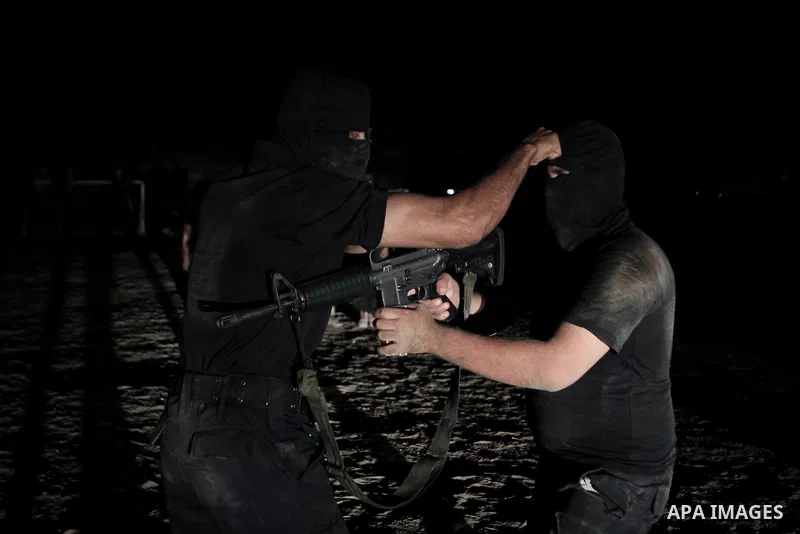 Palestinian militants of al-Nasser Salah al-Din Brigades, the armed wing of the Popular Resistance Committees (PRC), take part in a night military-style exercises at a training camp in Rafah in the southern Gaza Strip, A...
