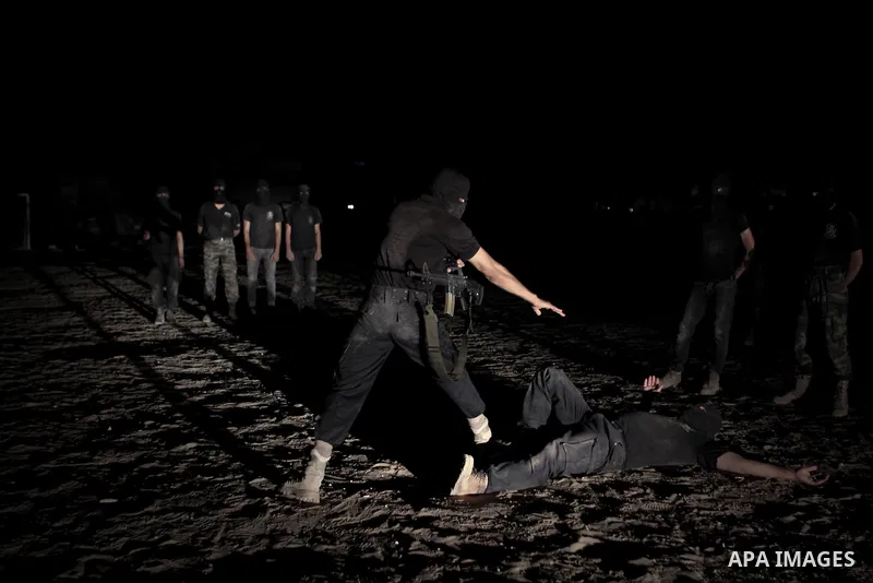Palestinian militants of al-Nasser Salah al-Din Brigades, the armed wing of the Popular Resistance Committees (PRC), take part in a night military-style exercises at a training camp in Rafah in the southern Gaza Strip, A...