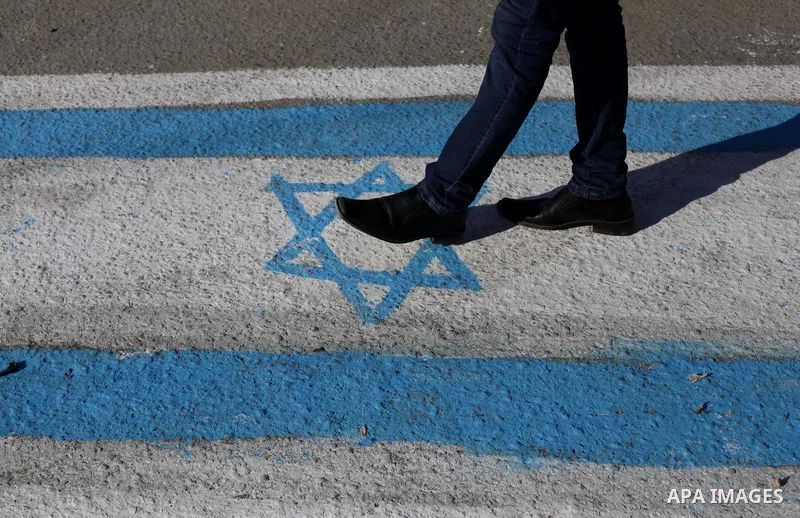 A Palestinian supporter of Popular Front for the Liberation of Palestine (PFLP) walks on an Israeli flag during a rally marking the 12th anniversary of the killing of Abu Ali Mustafa, leader of (PLFP), in Gaza City Augus...