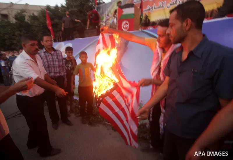 Palestinian supporters of Popular Front for the Liberation of Palestine (PFLP) burn a U.S. flag during a rally marking the 12th anniversary of the killing of Abu Ali Mustafa, leader of (PLFP), in Gaza City August 27, 201...