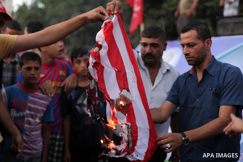 Palestinian supporters of Popular Front for the Liberation of Palestine (PFLP) burn a U.S. flag during a rally marking the 12th anniversary of the killing of Abu Ali Mustafa, leader of (PLFP), in Gaza City August 27, 201...