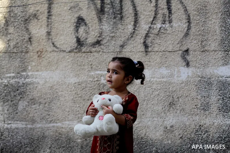A Palestinian girl plays in front of her family's home at al-Shati refugee camp, in Gaza City on Aug 29, 2013. Photo by Ashraf Amra