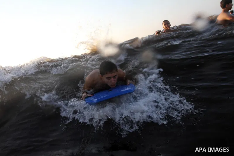 Palestinians enjoy swimming in the sea at Gaza beach during the weekend western Gaza City on Aug 30, 2013. Photo by Mohammed Asad