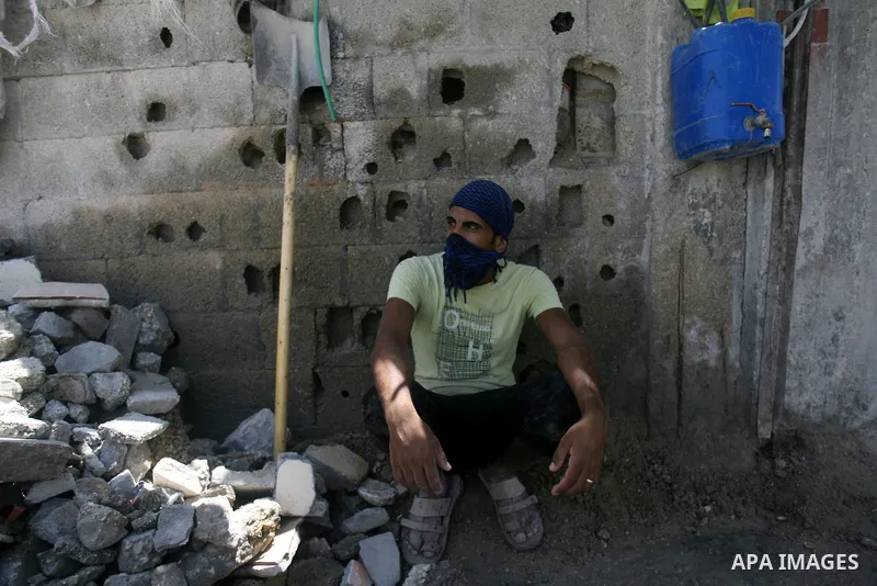 A Palestinian laborer works on a crusher machine at a brick factory in Rafah in southern Gaza Strip, Aug 31, 2013. Palestinians re-use old bricks in construction after the Egyptian army started to knock down Gaza smuggli...