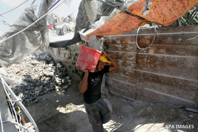 A Palestinian laborer works on a crusher machine at a brick factory in Rafah in southern Gaza Strip, Aug 31, 2013. Palestinians re-use old bricks in construction after the Egyptian army started to knock down Gaza smuggli...