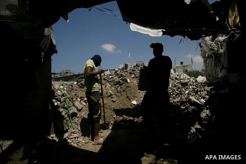 Palestinian laborers work on a crusher machine at a brick factory in Rafah in southern Gaza Strip, Aug 31, 2013. Palestinians re-use old bricks in construction after the Egyptian army started to knock down Gaza smuggling...