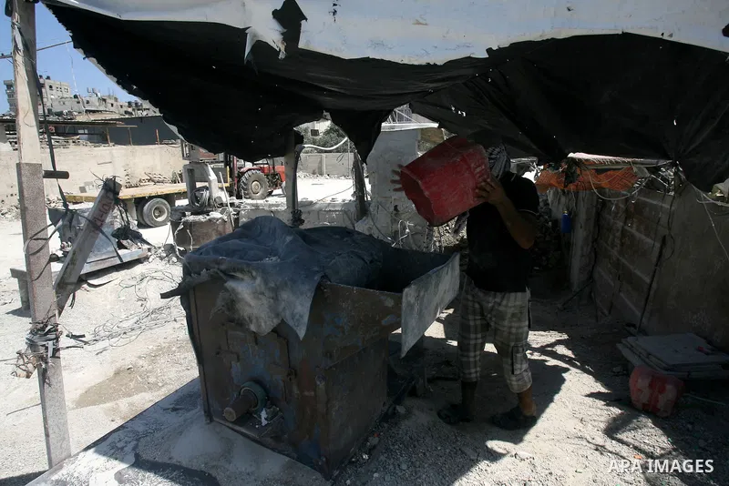 A Palestinian laborer works on a crusher machine at a brick factory in Rafah in southern Gaza Strip, Aug 31, 2013. Palestinians re-use old bricks in construction after the Egyptian army started to knock down Gaza smuggli...