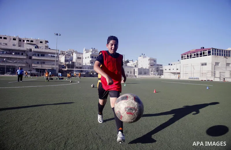 Palestinian boys play soccer during training exercises at a playground in Jerusalem, Aug. 31, 2013. About 200 Palestinian boy from the West Bank participated in the exercises to join the Palestinian Football Academy for...