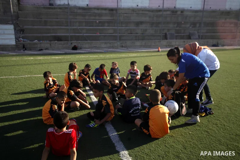 Palestinian boys play soccer during training exercises at a playground in Jerusalem, Aug. 31, 2013. About 200 Palestinian boy from the West Bank participated in the exercises to join the Palestinian Football Academy for...