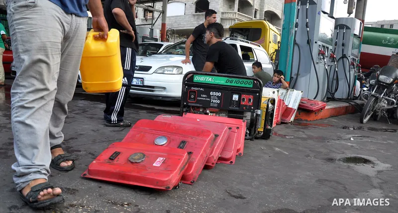 Palestinians wait to fill containers with fuel from a petrol station in Gaza city on Sep 01, 2013. Fuel stations in the Gaza Strip free of fuel due to the crisis in Egypt and the restricting of the fuel lines through the...