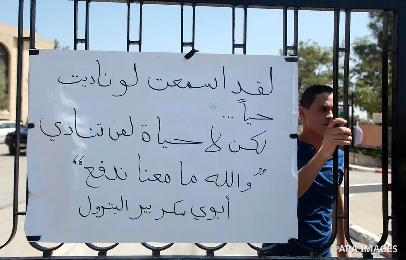 A Palestinian student of Birzeit University stands in front of his University as others protest against rising of the tuition fees, near the West Bank City Ramallah, 02 September 2013. Photo by Issam Rimawi