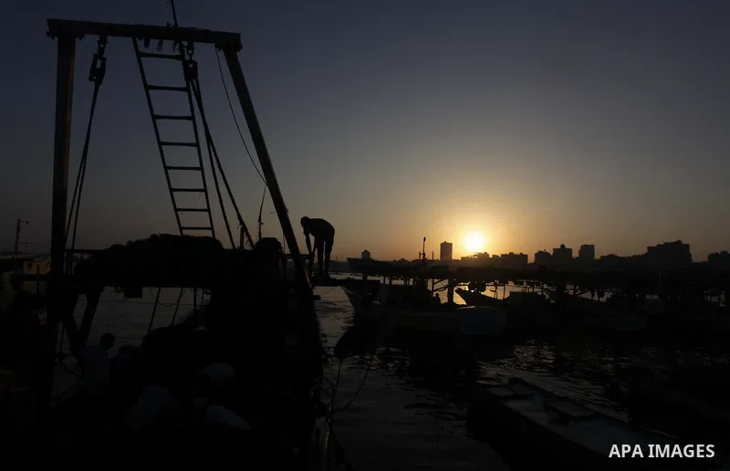 A Palestinian fisherman works on his boat during the sunrise at the Gaza seaport in the west of Gaza City, 02 September 2013.The Egyptian navy boats attacked the Palestinian boats off the southern Gaza Strip last Friday,...