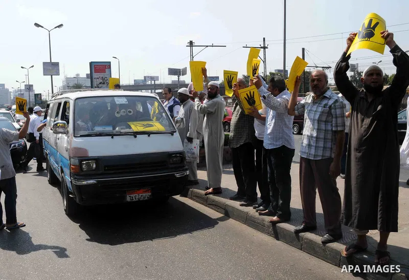 Supporters of Egypt's ousted President Mohammed Morsi chant slogans and hold placards showing an open palm with four raised fingers, which has become a symbol of the Rabaah al-Adawiya mosque, where Morsi supporters had h...