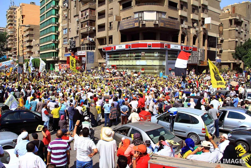 Supporters of Egypt's ousted President Mohammed Morsi chant slogans and hold placards showing an open palm with four raised fingers, which has become a symbol of the Rabaah al-Adawiya mosque, where Morsi supporters had h...