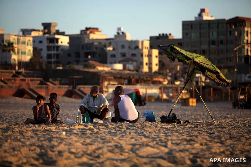 Palestinian men enjoy to sit on the Gaza beach in Gaza City on Sep. 08, 2013. Photo by Ashraf Amra