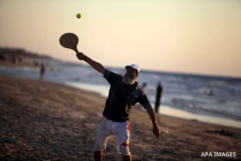 A Palestinian man plays the tennis play on the sea at Gaza beach in Gaza City on Sep. 08, 2013. Photo by Ashraf Amra