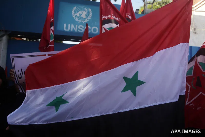Palestinians hold banners and wave the Syrian flag as they take part in a rally, organized by the Palestinian leftist party, the Popular Front for the Liberation of Palestine (PFLP), against US military action on Syria,...